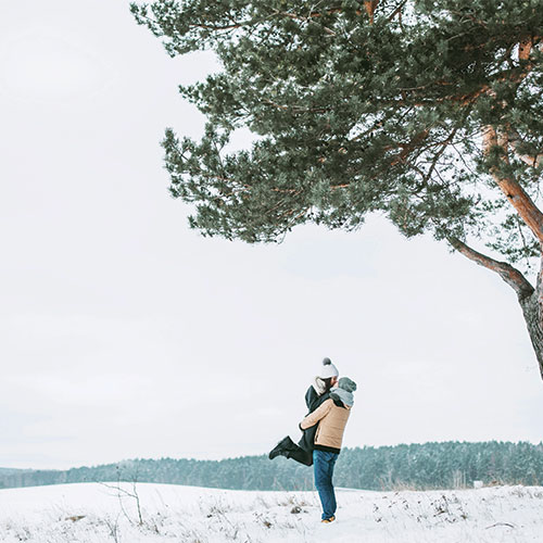 couple heureux dans la neige et sentiment de liberté