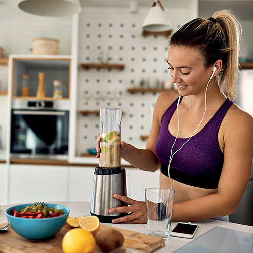 femme sportive préparant un smoothie