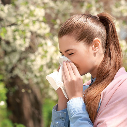 Femme se mouchant souffrant d'une allergie